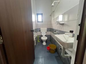 a small bathroom with a toilet and a sink at Mundodan complex in Nilambūr