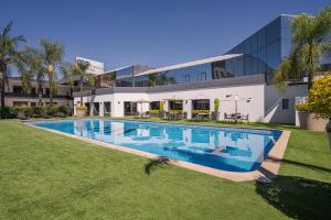 a swimming pool in front of a building at Hotel Malibu in Guadalajara