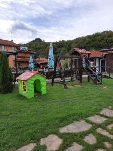 a green play house in the grass with a playground at Complex Balkandzhii in Apriltsi