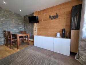 une cuisine avec une table, une télévision, une table et des chaises dans l'établissement Studio central avec superbe vue sur les montagnes, à Huez