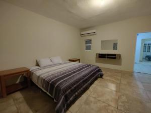 ein Schlafzimmer mit einem Bett in einem weißen Zimmer in der Unterkunft Valle del Sol in Senecú