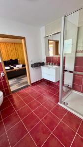 a bathroom with a red tiled floor and a shower at Gemütliche Auszeit in Burg