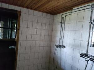 a shower in a bathroom with white tiles at Hillavilla in the shore of lake Inari in Inari +41 photos