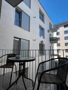 a balcony with a table and chairs and a building at Apartament central Blaj in Blaj
