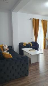 a living room with a blue couch and a white table at Apartament central Blaj in Blaj