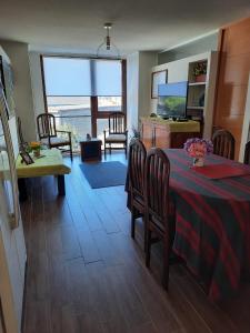 Una sala de estar con mesa y sillas y una cocina. en Energía del Sur, en Puerto Montt