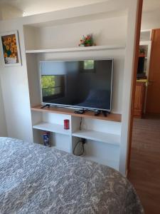 Un dormitorio con un televisor de pantalla plana y una cama. en Energía del Sur, en Puerto Montt