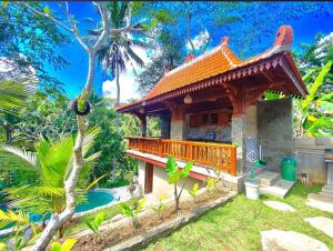 Una pequeña casa con balcón en un jardín. en Chaplet House, en Ubud