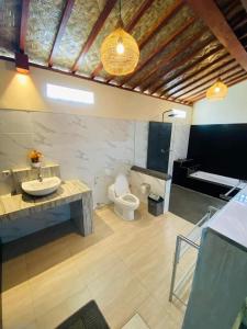 Un baño con lavabo e inodoro en una habitación. en Chaplet House, en Ubud