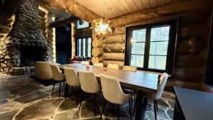 a dining room with a wooden table and chairs at Nilirakka - Luxury log Chalet in Levi in Levi