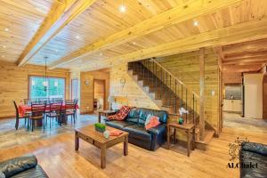 un soggiorno con un divano e un tavolo di La Maison Eden Sauna & Spa Near Le Massif de Charlevoix a Petite-Rivière-Saint-François