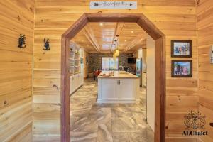 una cucina con pareti in legno e bancone in camera di La Maison Eden Sauna & Spa Near Le Massif de Charlevoix a Petite-Rivière-Saint-François Altre 25 foto