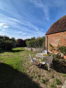ein Tisch und Stühle in einem Hof neben einem Backsteingebäude in der Unterkunft Manor Cottage in Downton