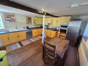 a kitchen with a wooden table and stainless steel appliances at Manor Cottage in Downton