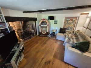 ein Wohnzimmer mit Sofa und Fernseher in der Unterkunft Manor Cottage in Downton