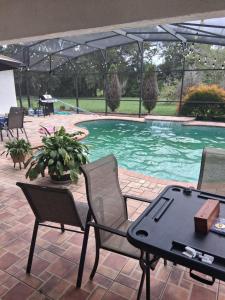a patio with a table and chairs next to a pool at Suite privada en orlando kissimmee con piscina privada in Kissimmee