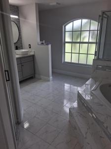 a bathroom with a tub and a sink and a mirror at Suite privada en orlando kissimmee con piscina privada in Kissimmee