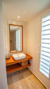 a bathroom with a sink and a mirror at Villa Mire - Domaine de la maison blanche in Terre-de-Haut