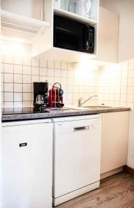 a kitchen with white appliances and a counter top at Résidence Les Campanules - Les Campanules CA24FB MAE-1303 in La Norma +4 photos