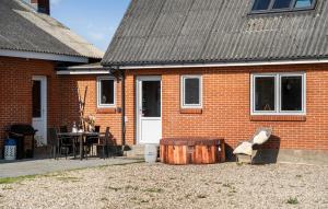 Lyngsにある2 Bedroom Amazing Home In Thyholmの前に木製の樽がある赤レンガの家
