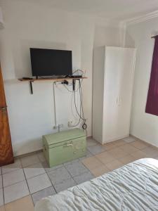 ein Schlafzimmer mit einem Bett und einem Fernseher an der Wand in der Unterkunft Reconquista Temporarios in Reconquista
