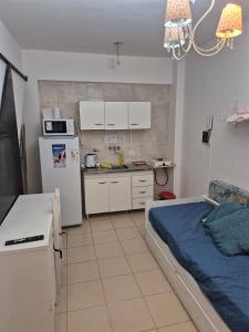 ein Zimmer mit Küche mit Bett und Kühlschrank in der Unterkunft Reconquista Temporarios in Reconquista