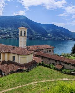 a building with a clock tower next to a body of water at Sebino Holiday Home Monteisola in Monte Isola