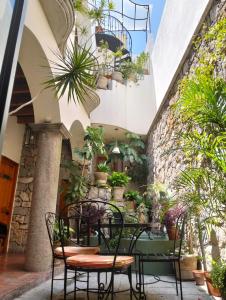 a patio with a table and chairs and potted plants at Hotel Antigua Casa de Piedra in San Miguel de Allende +56 photos