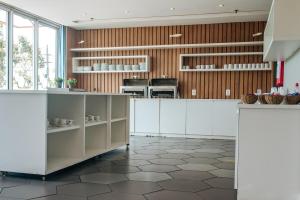 a large kitchen with white cabinets and a tile floor at Flat Hotel Bossa Nova Cabo Frio Passagem in Cabo Frio