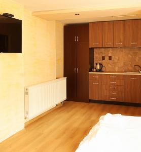 a kitchen with wooden cabinets and a white radiator in a room at Guest house Dinaya-2 in Dobrinishte +12 photos