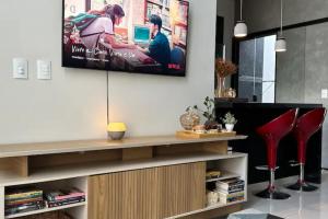 a living room with a flat screen tv on a wall at Casa Charmosa Próxima a Avenida das Cataratas in Foz do Iguaçu