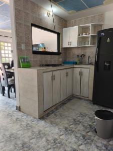 a kitchen with white cabinets and a black refrigerator at Las Margaritas Frente al Mar 1 in Coveñas