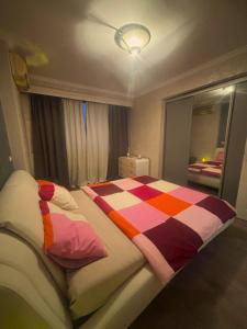 蒂米什瓦拉CENTRAL 2 CAMERE CU VIEW P-ta VICTORIEI的卧室里有一张大床，床铺上还有色彩缤纷的枕头 更多6张照片