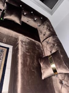 a brown leather couch with pillows on it at MandéHabitat in Bamako