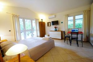 een slaapkamer met een bed en een bureau met een laptop bij casaisoladelba immersa nel verde a 80mt dalla spiaggia in Lacona