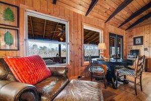 Una sala de estar con un sofá de cuero y una mesa. en Lake Lahusage Front - Private Dock, Game Room, en Mentone