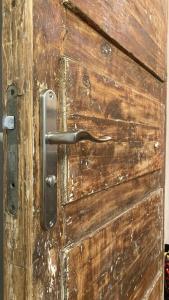 a wooden door with a metal handle on it at Āgenskalns 2 in Riga