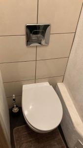 a small bathroom with a toilet with a paper dispenser on the wall at Āgenskalns 2 in Riga +12 photos
