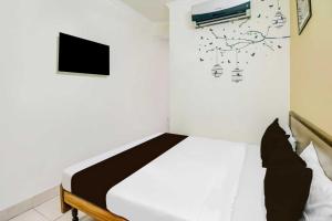 a bedroom with a bed and a tv on a wall at Super Hotel O Sindhi Camp Formerly Hotel Paul Avenue in Jaipur