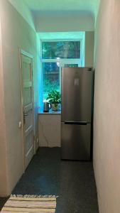 a kitchen with a stainless steel refrigerator and a window at Āgenskalns 2 in Riga