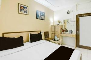 a bedroom with a white bed and a kitchen at Super Hotel O Sindhi Camp Formerly Hotel Paul Avenue in Jaipur +20 photos