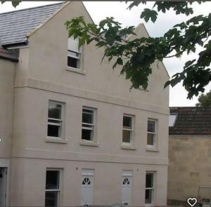 un bâtiment blanc avec plusieurs fenêtres sur son côté dans l'établissement The Bath House Apartments - Free 1st breakfast - FREE parking, à Bath