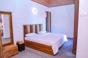 a bedroom with a large bed and a mirror at Villa de sunrise garden 