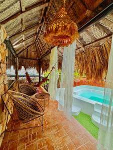a room with a chandelier and a swimming pool at Monte Verde Tayrona in El Zaino