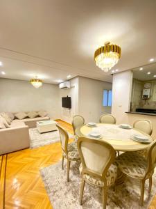 a living room with a table and chairs and a couch at San Stefano Sea view New Luxury Apartment in Alexandria