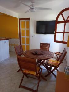 a dining room with a table and chairs and a tv at Gîte des voyageurs in Vieux-Habitants
