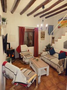 Una sala de estar con sofás y una mesa. en Casa Rural El Refugio, en Zuheros