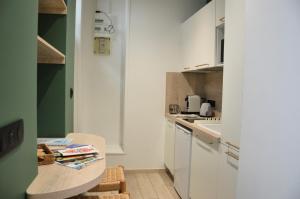 a small kitchen with a table and a counter at Suite cosy & centrale I Lit queen size I Balnéo in Aurillac