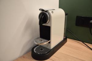 a black and white appliance sitting on the floor at Suite cosy & centrale I Lit queen size I Balnéo in Aurillac