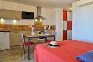 una camera con letto e una cucina con tavolo di Residence Roc E Mare Tiuccia a Tiuccia